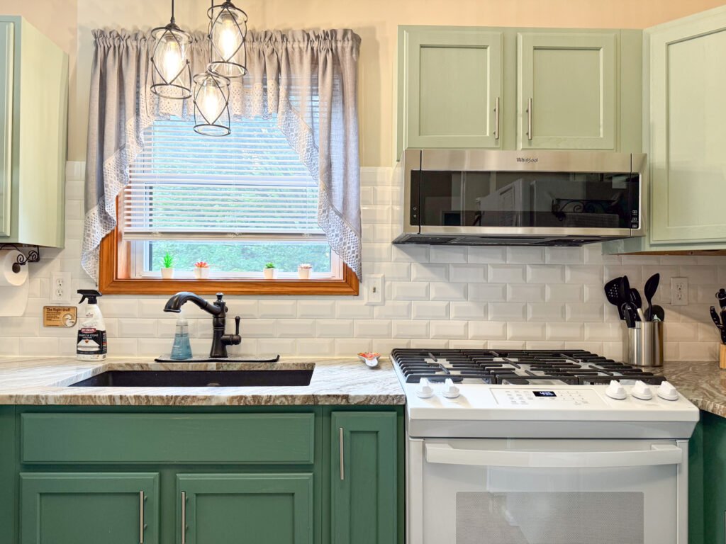 Updated kitchen with white appliances and aspen green cabinets at the Quiet Pond Lookout vacation rental property.